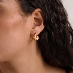 Side-stone hoop worn at the earlobe