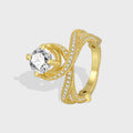 gold plated brass cross-over ring with round clear center stone