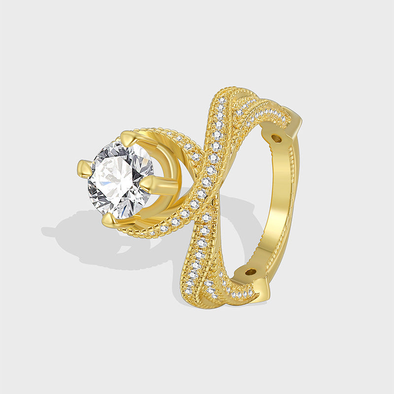 gold plated brass cross-over ring with round clear center stone