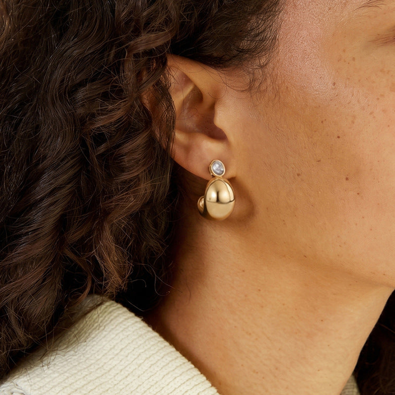 Domed clear accent earring worn in profile