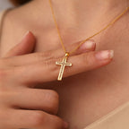clear-stone cross pendant necklace worn at the collarbone