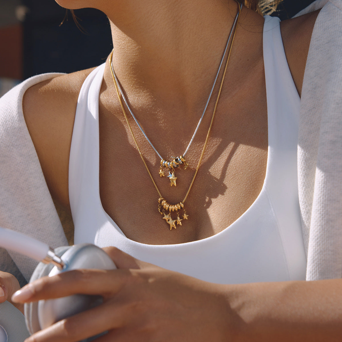 Gold and two-tone star cluster necklaces layered on a model
