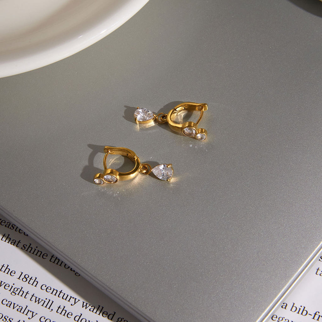 Round-accent huggies with pear drops on a table
