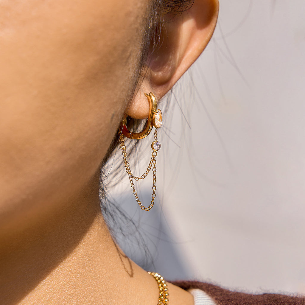 model wearing gold plated double-chain drop hoop earrings