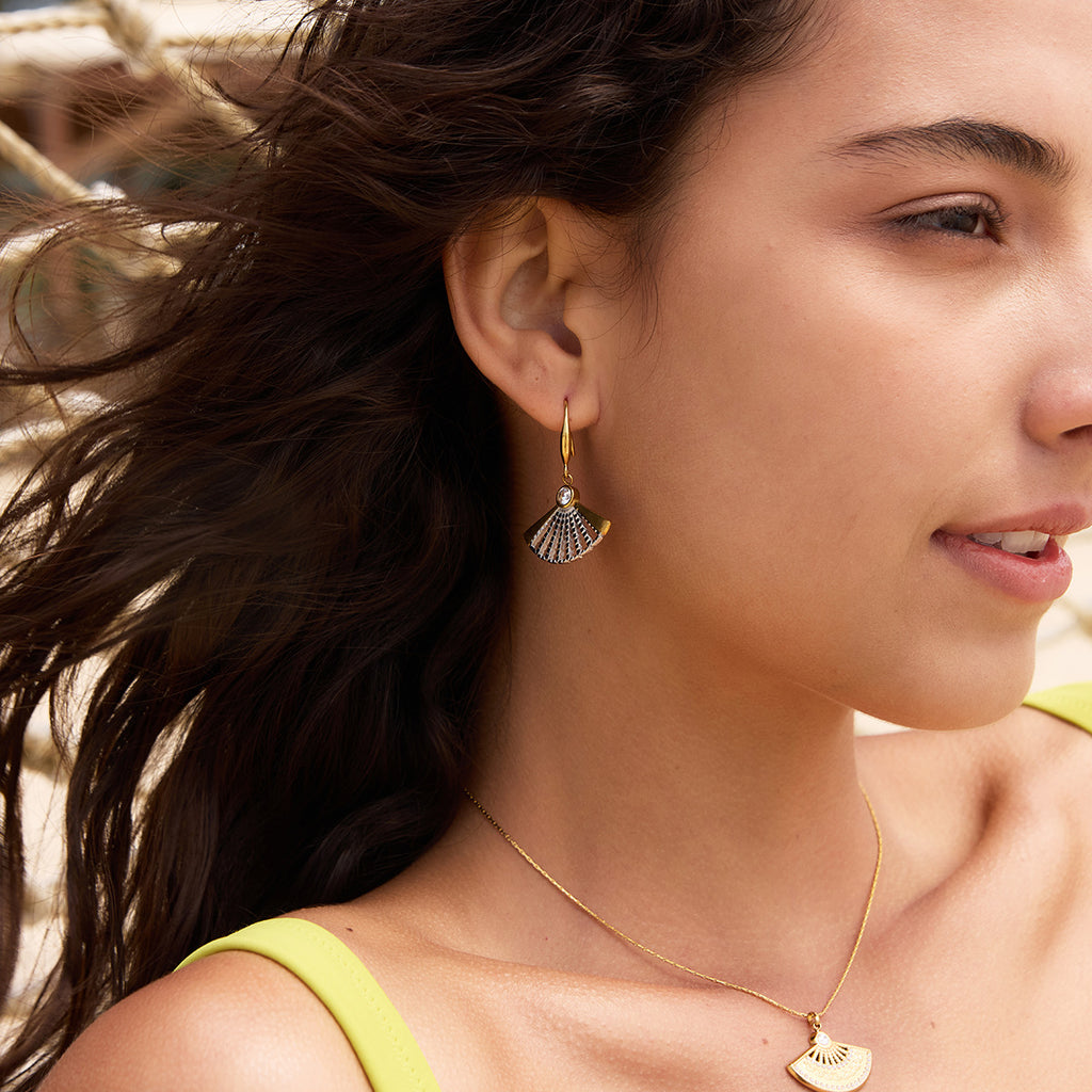 Two-tone fan earrings worn with a pendant