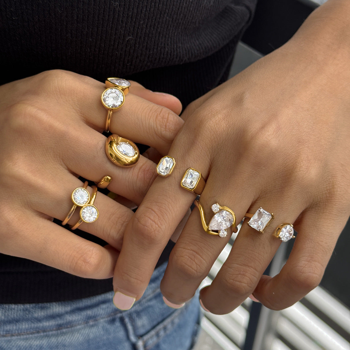 Six asymmetric clear stone rings styled on hands