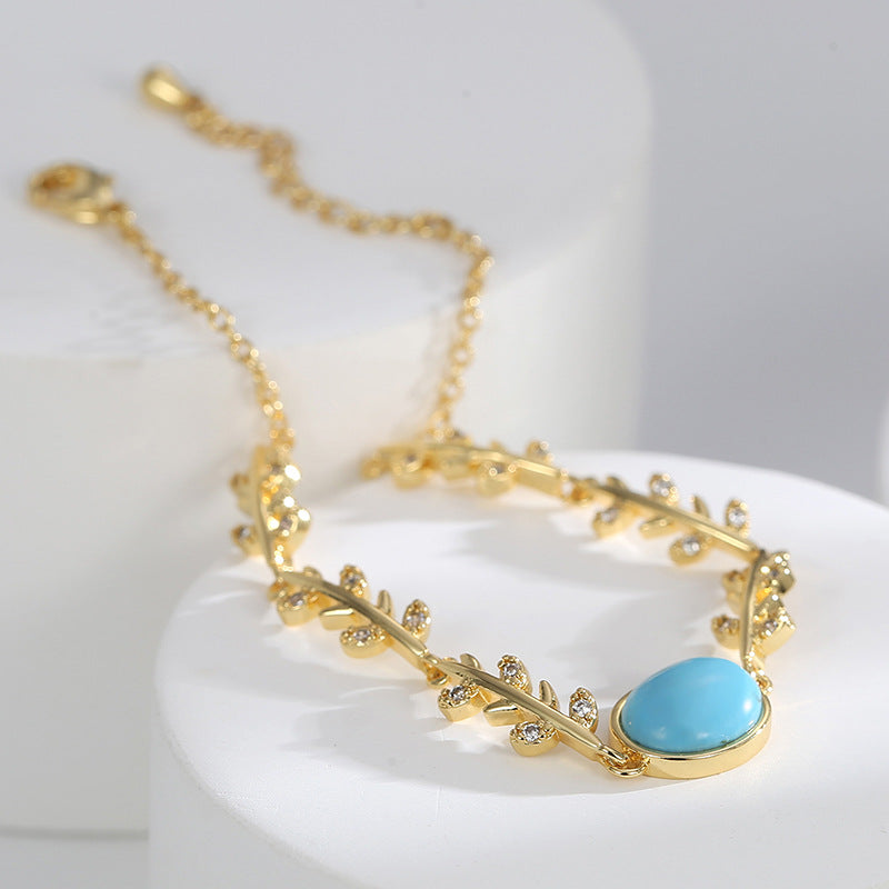 close view of gold plated leaf links and clear faceted accents
