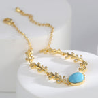 close view of gold plated leaf links and clear faceted accents