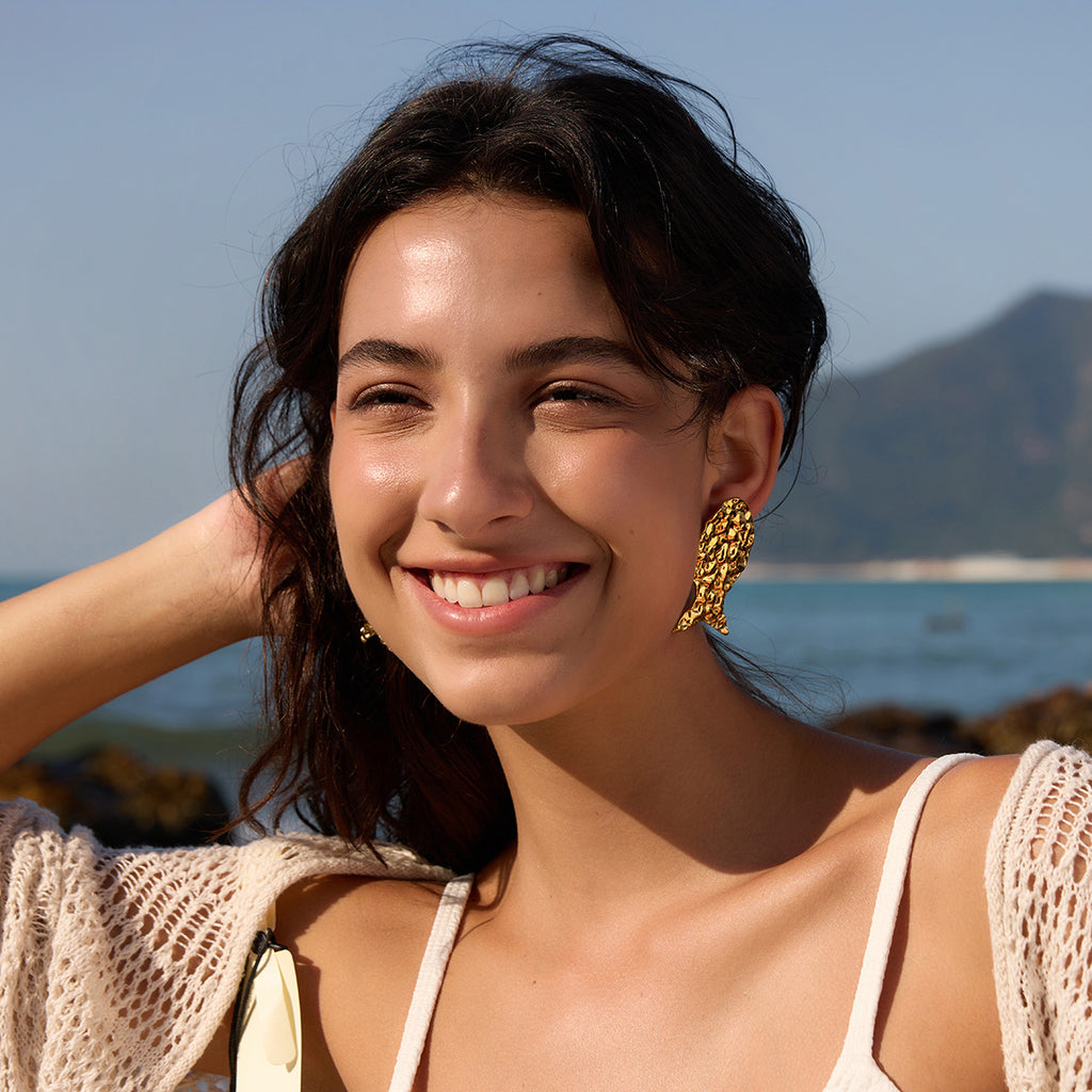 Textured fish stud earring worn on the ear