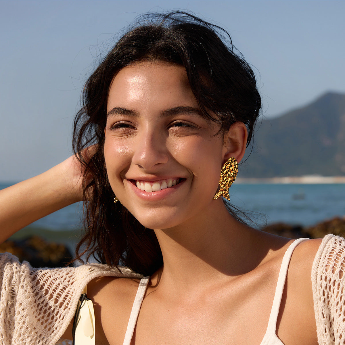 Textured fish stud earring worn on the ear