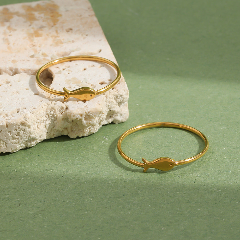 Gold Plated 316L Stainless Steel Small Fish Band Ring — two rings on stone and green background