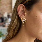 Pear zirconia inside a sculptural earring shown on a lobe