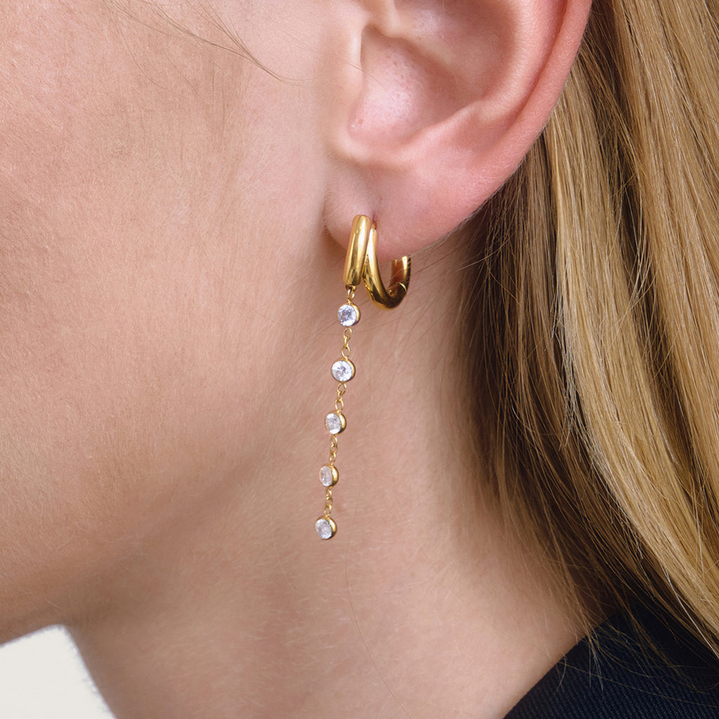 long clear stone drop huggie earring worn from the side