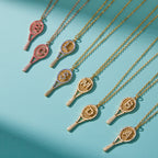 Tennis racket initial necklaces arranged on blue