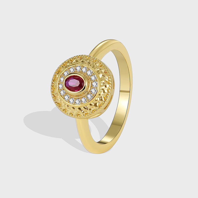 isolated gold plated red and clear stone medallion ring