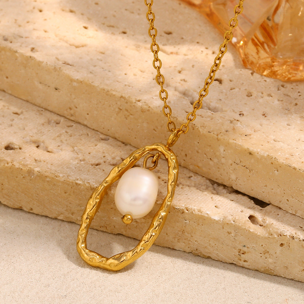 gold plated pearl-style pendant necklace displayed on pale stone