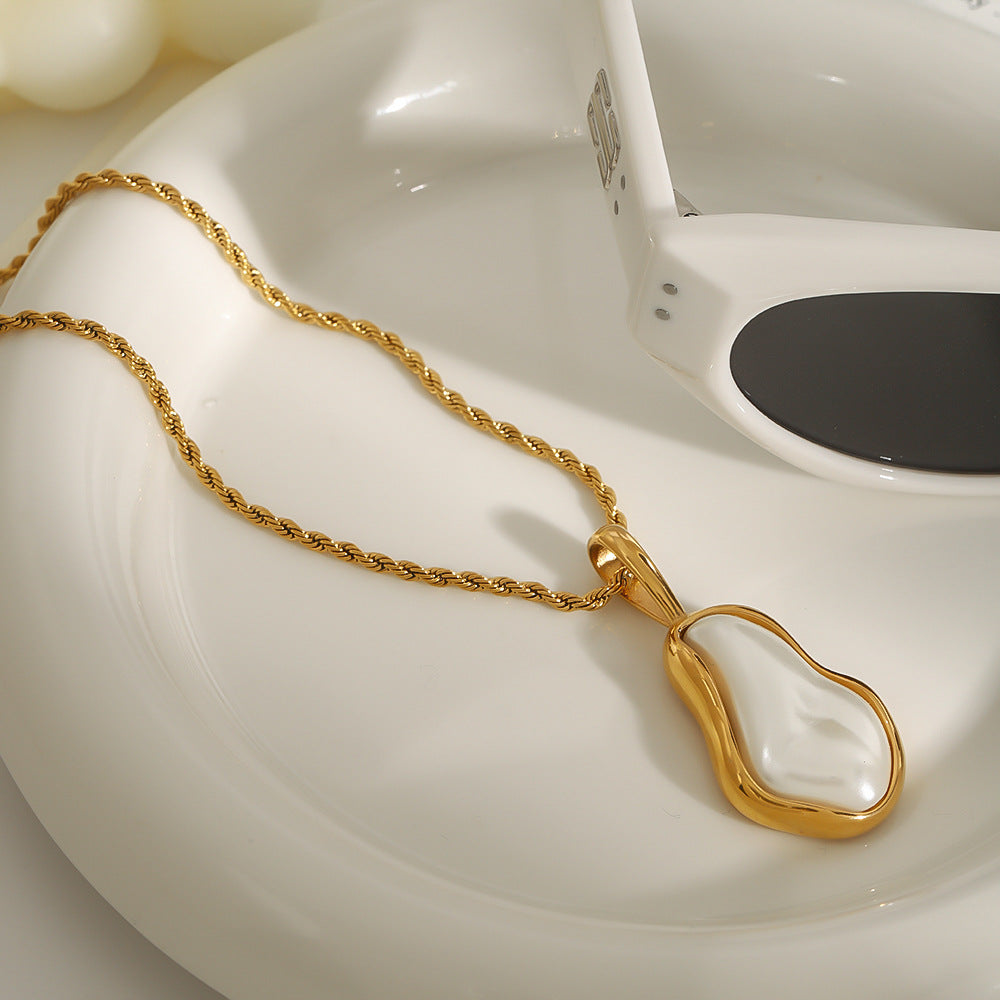 Framed pearl-look pendant and twisted chain on a dish