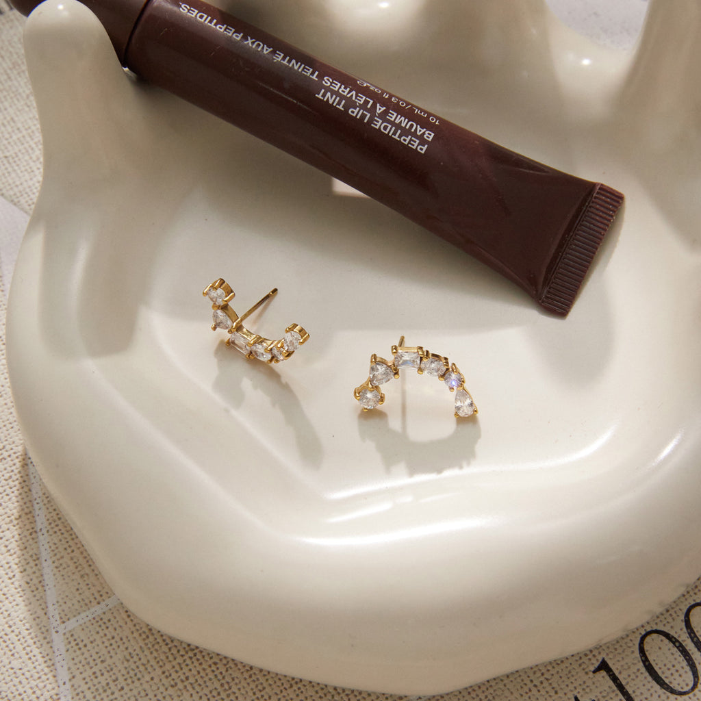 Curved earrings on a ceramic tray showing posts