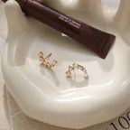 Curved earrings on a ceramic tray showing posts