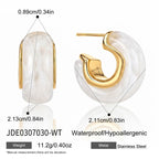 White faceted resin hoop with gold tone stainless steel setting