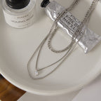 silver-finish layered necklace with small clear faceted pendant