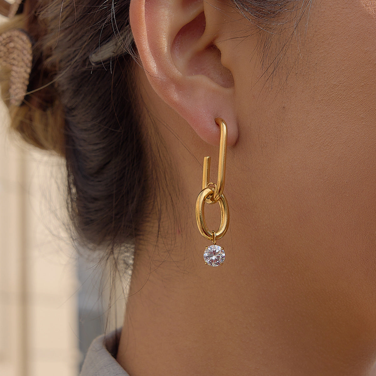 gold plated geometric link clear-stone drop earring worn on ear