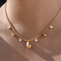gold plated teardrop charm station necklace worn at collarbone
