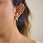 Green-accent hoop stud worn close-up