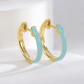 sky blue resin and gold plated huggie hoop earrings close-up