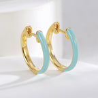 sky blue resin and gold plated huggie hoop earrings close-up