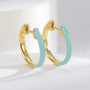 sky blue resin and gold plated huggie hoop earrings close-up