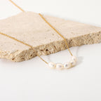 Five freshwater pearl necklace beside a stone block