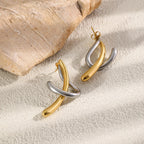 Polished curve earrings beside textured wood