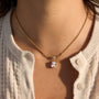 gold plated cushion stone drop necklace worn with a white cardigan