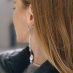 long mismatched white pearl-style bead earrings in side view