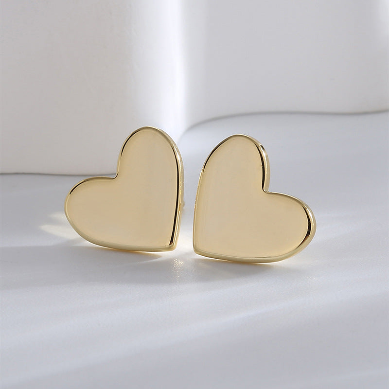 polished gold plated heart stud earrings in a close pair view