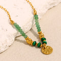 gold plated green bead necklace with sculpted spacers and textured coin charm