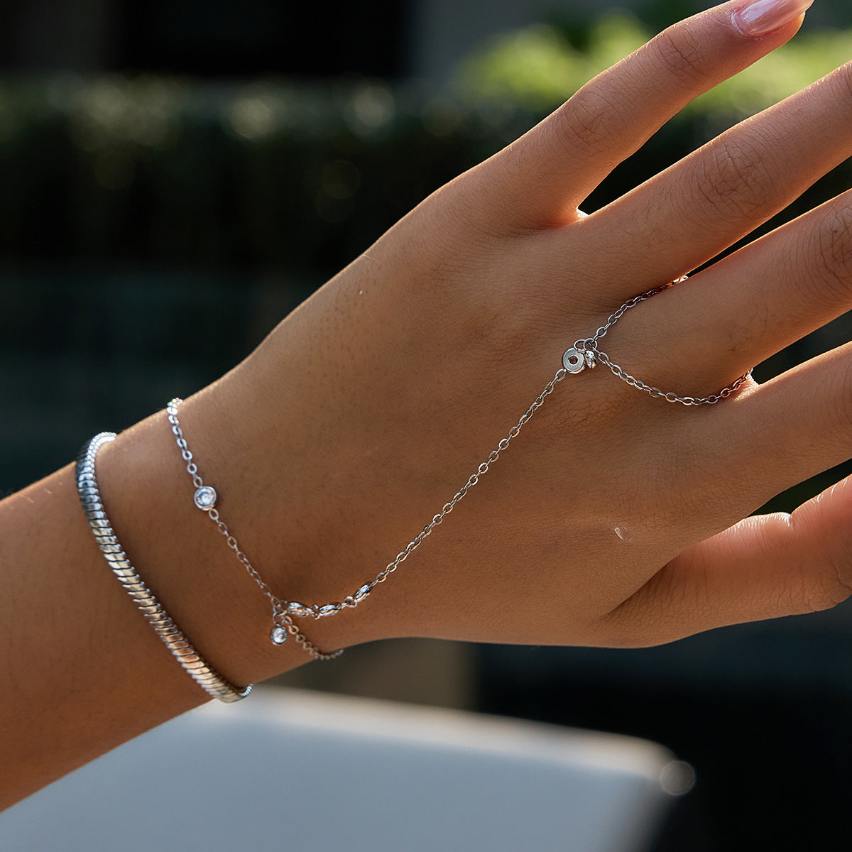Silver tone snake bracelet styled with separate hand jewelry
