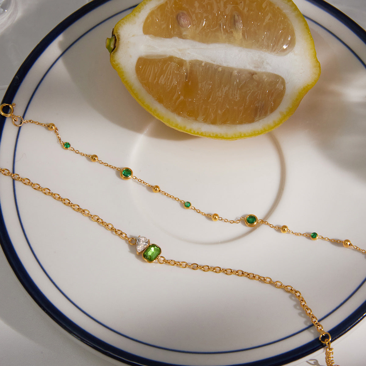 Green accent bracelets beside lemon slices