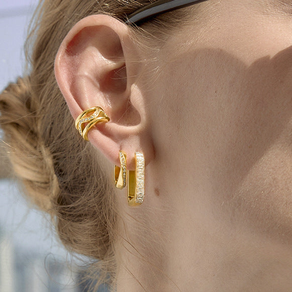 Twisted rhinestone hoop earrings styled on ear