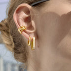 Twisted rhinestone hoop earrings styled on ear