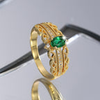 gold plated ornate ring reflected on a dark studio surface