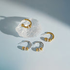 Both finishes of ring-accent hoops on a blue surface