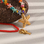 Close-up of gold tone marine pendants and colored beads