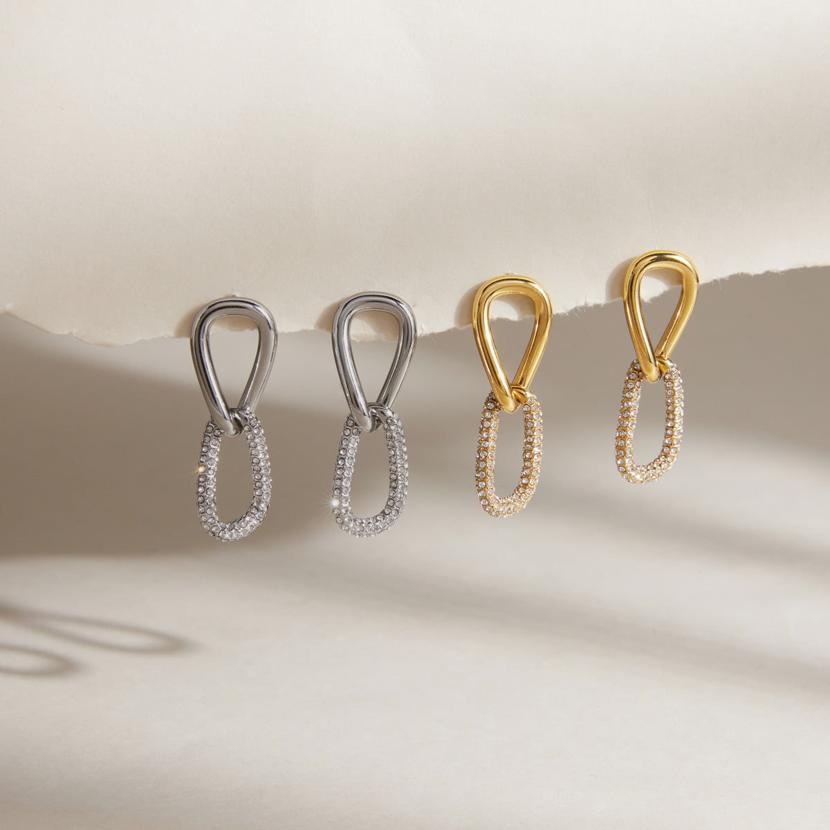 Gold and silver tone stone-accented link earrings displayed together