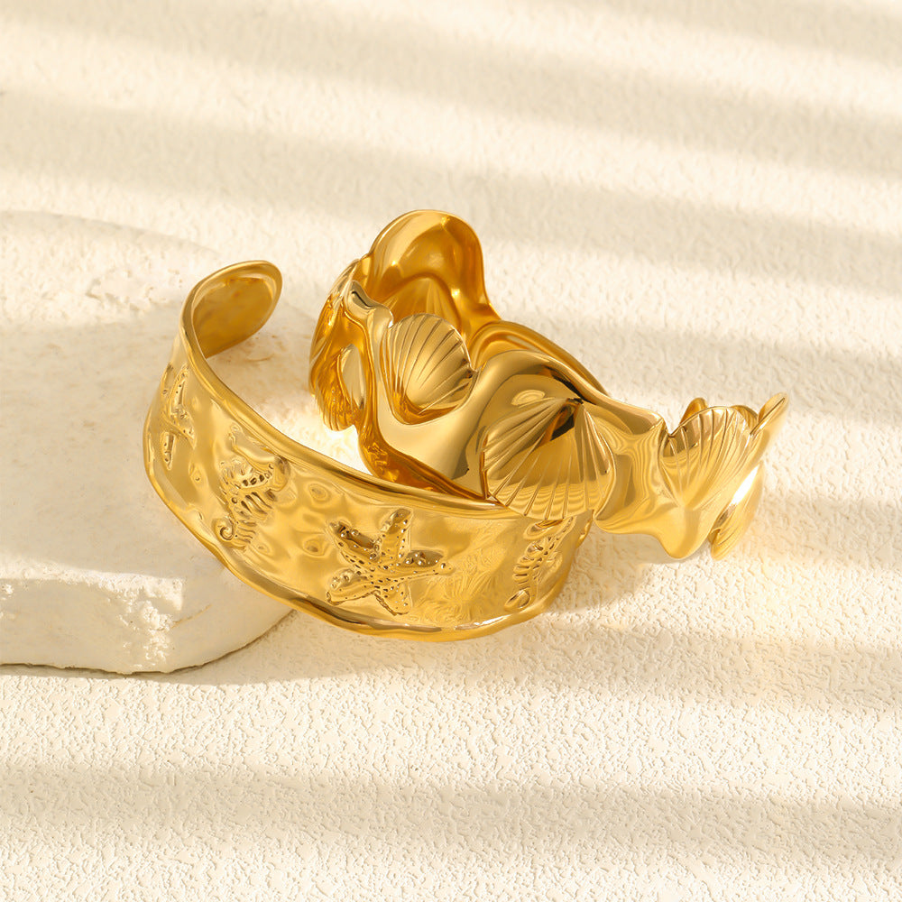 Sea-life relief cuff and sculpted shell cuff displayed together
