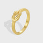 isolated gold plated brass ring with sculpted three-loop knot