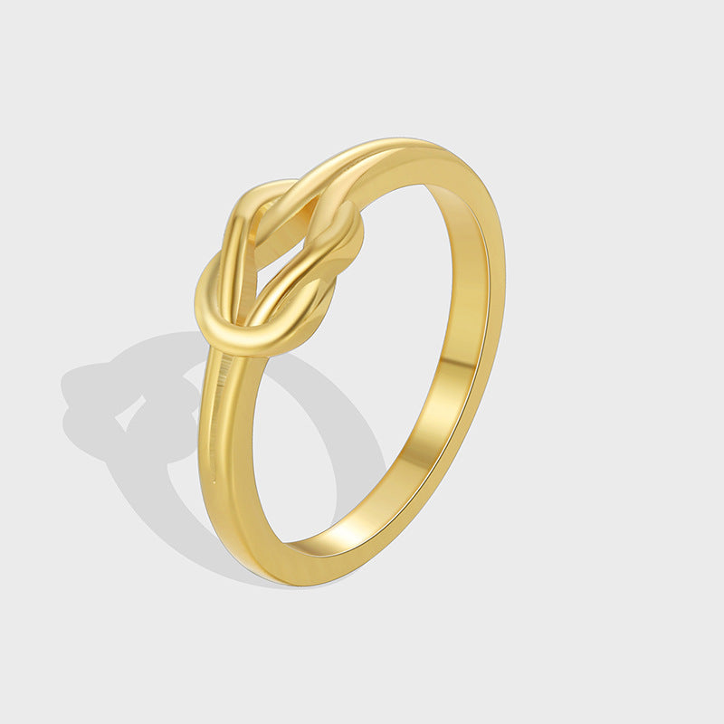 isolated gold plated brass ring with sculpted three-loop knot