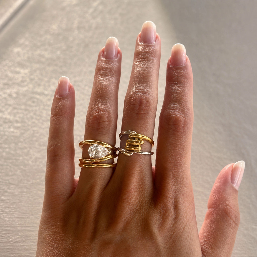 Two-tone loop ring worn beside a separate clear stone ring