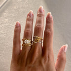 Two-tone loop ring worn beside a separate clear stone ring